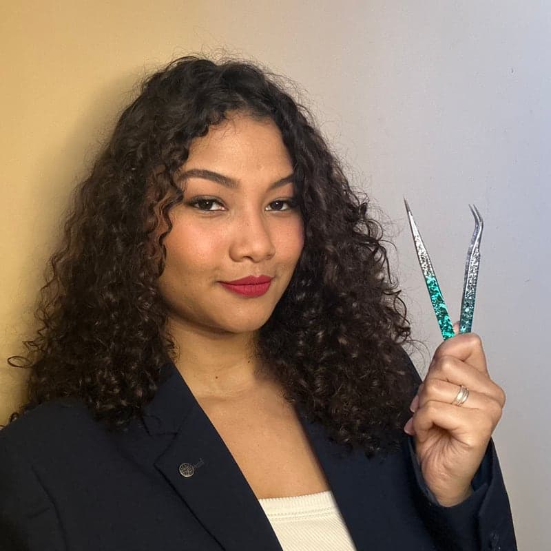 Rafaela Luca, lash designer, segurando uma pinça de extensão de cílios
